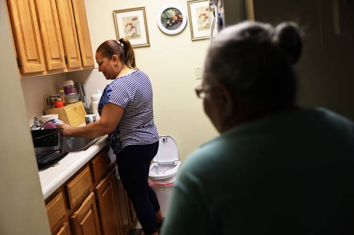 Lidia Vilorio, a home health aide, prepares a cup of tea for her patient Martina Negron on May 5, 2021 in Haverstraw, New York.